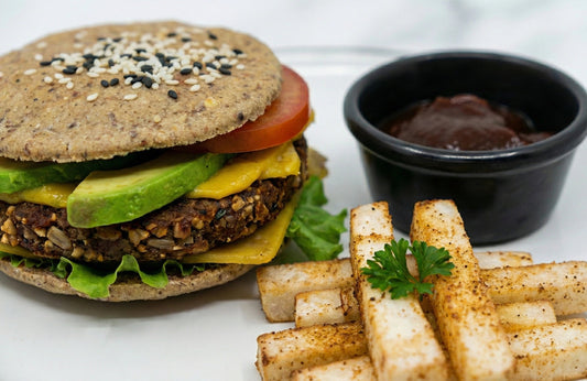 Vegan burger with fries and a side of ketchup on a white plate
