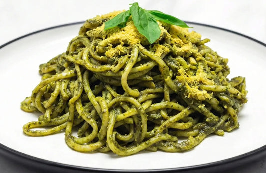 Pasta with green sauce on a white plate